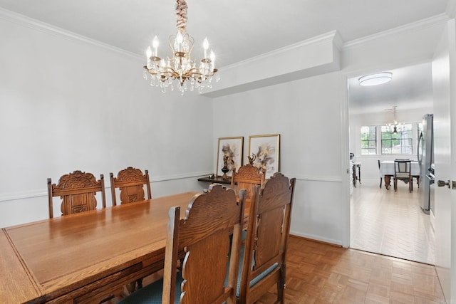 dining space with a chandelier, crown molding, and baseboards