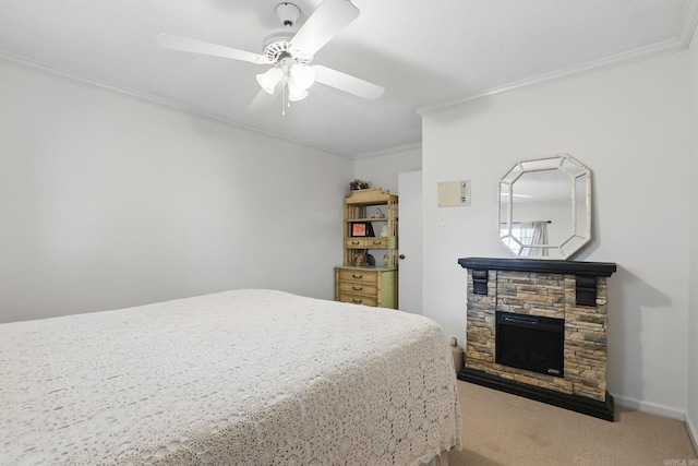 bedroom featuring ornamental molding, carpet, a stone fireplace, and ceiling fan