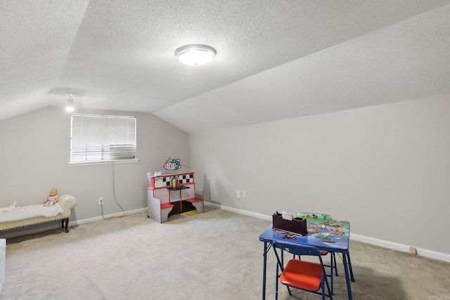 playroom featuring carpet, vaulted ceiling, a textured ceiling, and baseboards