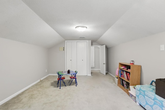 playroom featuring lofted ceiling, carpet flooring, baseboards, and a textured ceiling