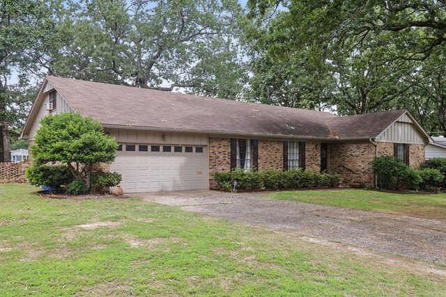ranch-style home featuring driveway, an attached garage, a front yard, and board and batten siding