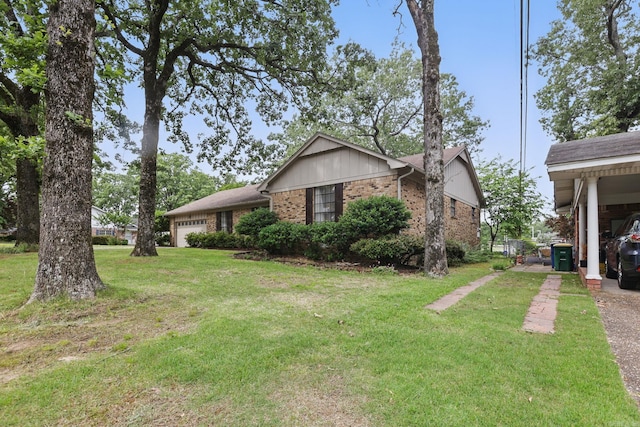 view of side of property with a yard, brick siding, and an attached garage