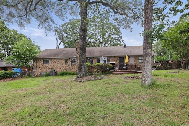 back of house with brick siding, a deck, and central AC