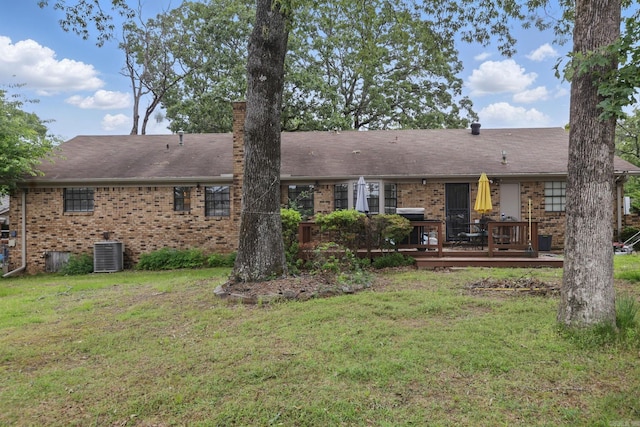 rear view of house featuring brick siding, a deck, central AC, and a lawn