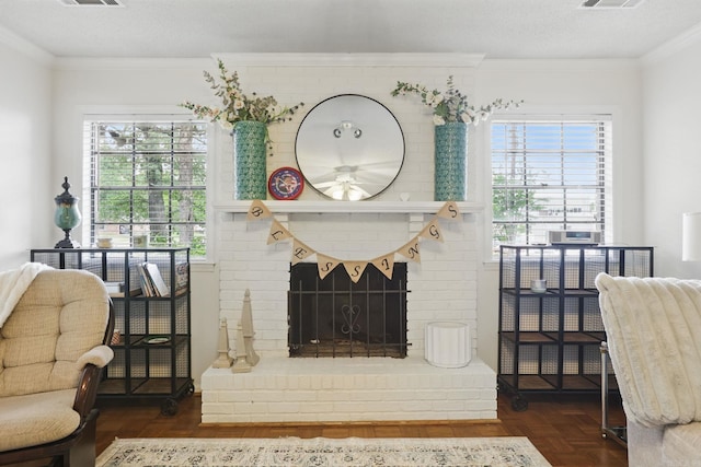 sitting room featuring ceiling fan, crown molding, and a brick fireplace