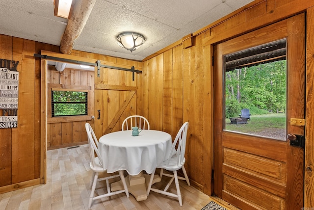 112 Fairchild Pt, Hot Springs, AR 71901 - dining space with a barn door, wood walls, and light wood-style floors