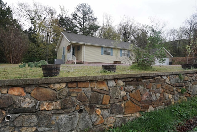 view of front facade with central air condition unit, a fire pit, and a front lawn