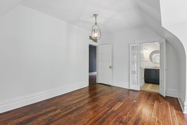 320 W 18th St, Little Rock, AR 72206 - unfurnished bedroom with dark wood-type flooring, lofted ceiling, ensuite bath, and baseboards