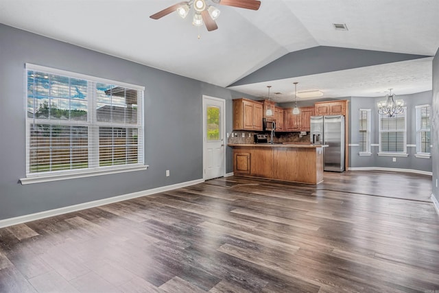 kitchen with appliances with stainless steel finishes, ceiling fan, open floor plan, a chandelier, and vaulted ceiling