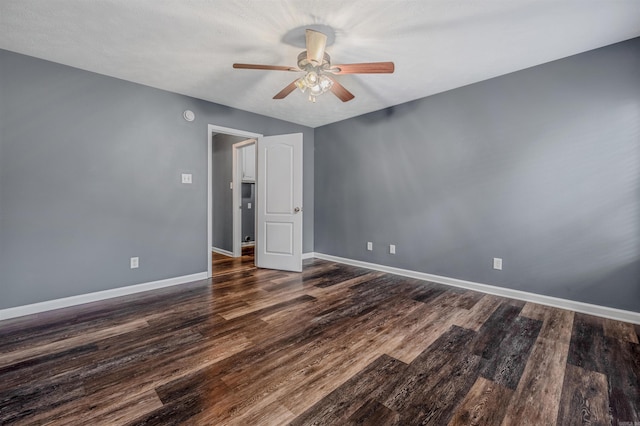 empty room with ceiling fan, wood finished floors, and baseboards
