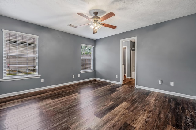 empty room with ceiling fan, wood finished floors, baseboards, and a textured ceiling