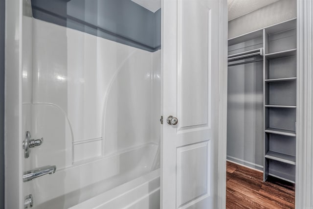 full bathroom with wood finished floors and shower / washtub combination