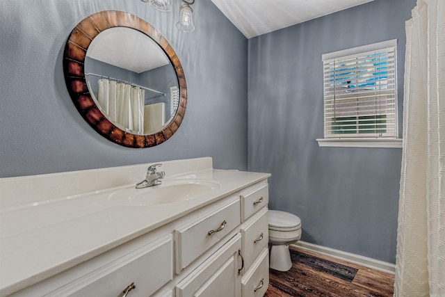 full bathroom with wood finished floors, baseboards, vanity, and toilet