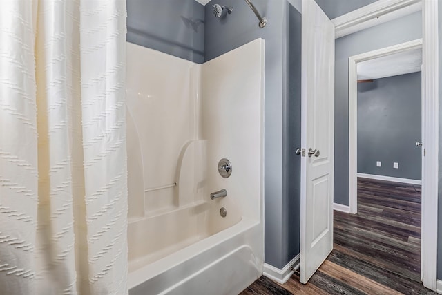 full bath with wood finished floors, shower / tub combo with curtain, and baseboards