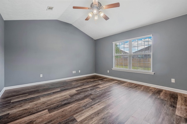spare room featuring dark wood-type flooring, ceiling fan, vaulted ceiling, and baseboards