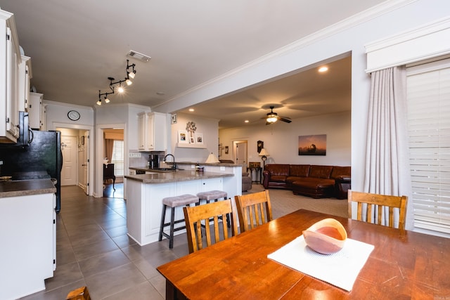 dining room with ornamental molding, dark tile patterned floors, ceiling fan, and rail lighting