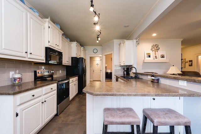 kitchen with black appliances, a sink, crown molding, a breakfast bar, and backsplash