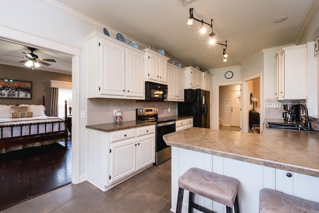 kitchen featuring black appliances, a sink, dark tile patterned floors, tasteful backsplash, and a ceiling fan