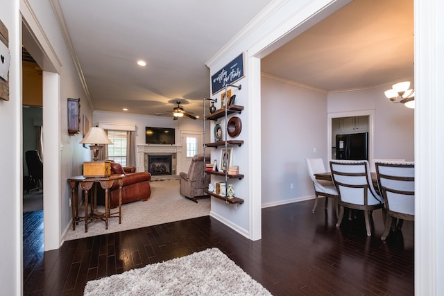 corridor with crown molding, baseboards, wood finished floors, recessed lighting, and a chandelier