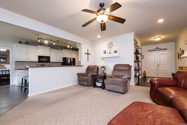 living area with ceiling fan, crown molding, baseboards, and track lighting