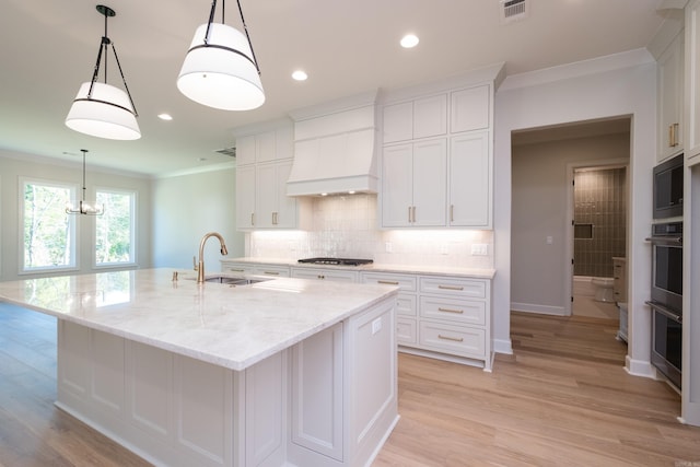20 Abington Ct, Little Rock, AR 72223 - kitchen featuring a sink, ornamental molding, white cabinets, tasteful backsplash, and a center island with sink