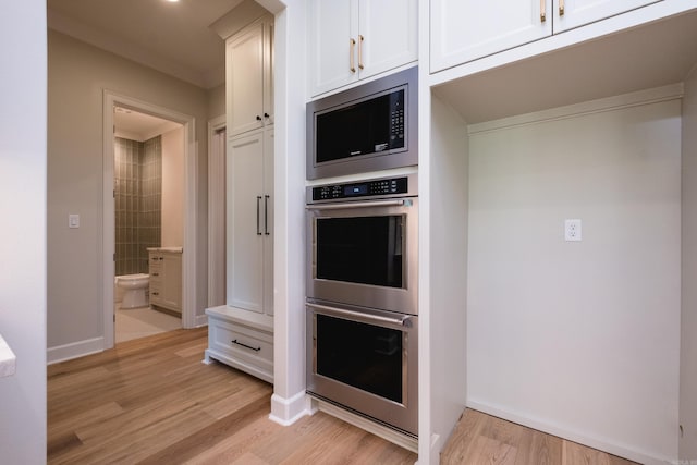 20 Abington Ct, Little Rock, AR 72223 - kitchen featuring appliances with stainless steel finishes, white cabinets, light wood-type flooring, and baseboards