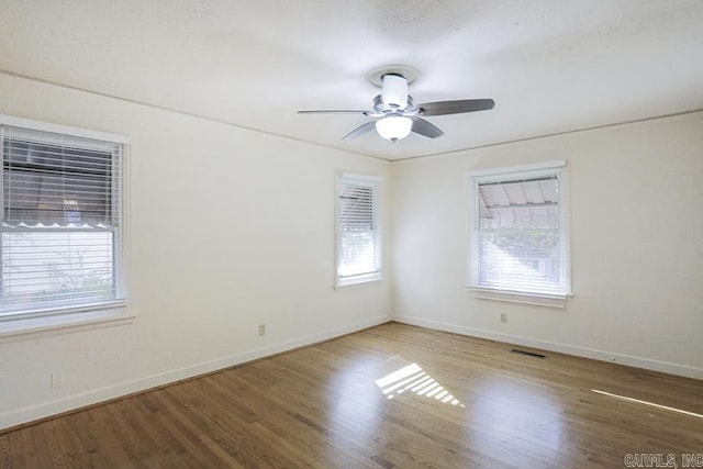 unfurnished room with wood finished floors, baseboards, and ceiling fan