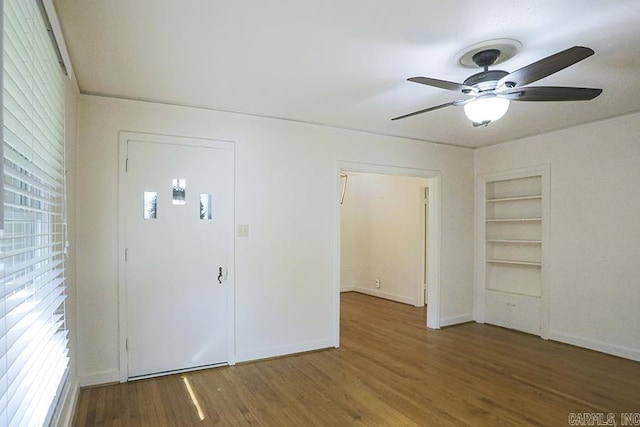 foyer entrance with ceiling fan, healthy amount of natural light, wood finished floors, and baseboards