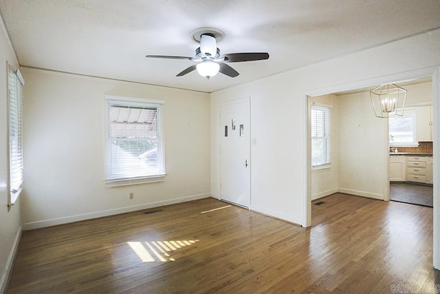 unfurnished bedroom featuring multiple windows, wood finished floors, and baseboards
