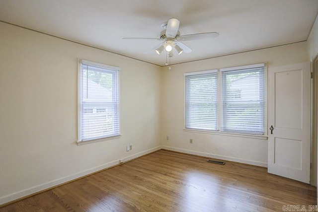 empty room featuring baseboards, ceiling fan, and wood finished floors