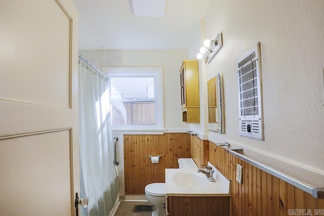 full bath with wainscoting, toilet, vanity, and wood walls