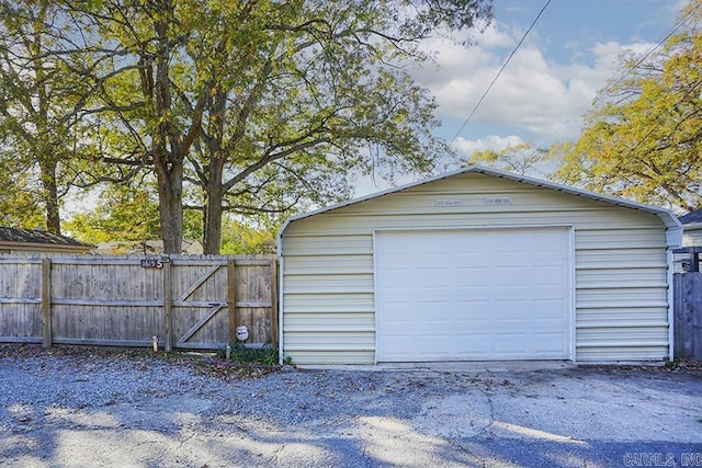 detached garage with fence and a gate