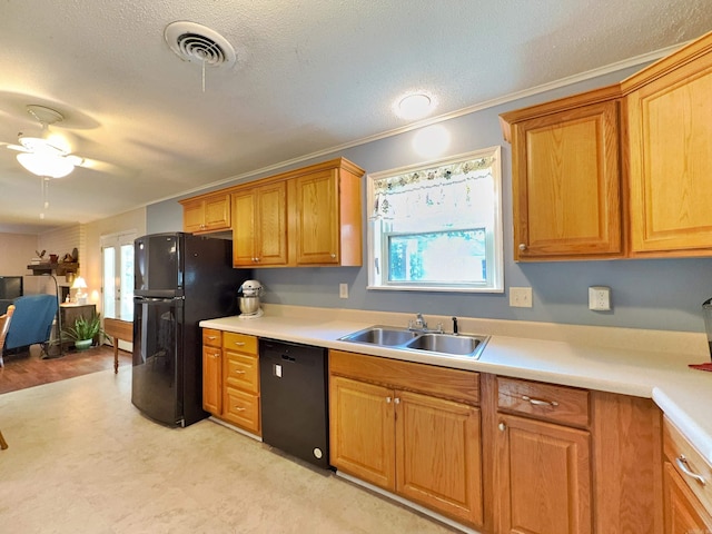 kitchen with black appliances, a sink, plenty of natural light, light countertops, and ornamental molding