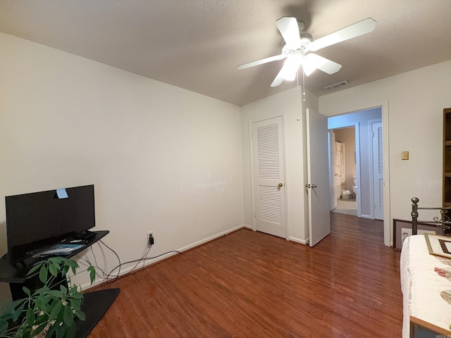 unfurnished bedroom with wood finished floors, ceiling fan, baseboards, and a closet