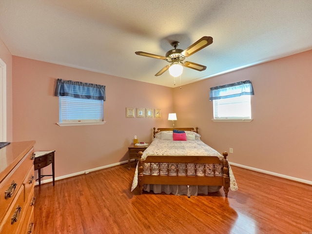 bedroom featuring wood finished floors, baseboards, and ceiling fan