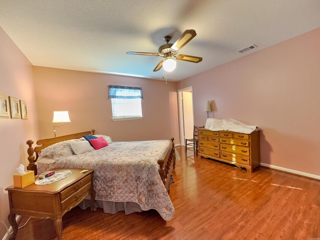 bedroom featuring light wood-type flooring, a ceiling fan, and baseboards