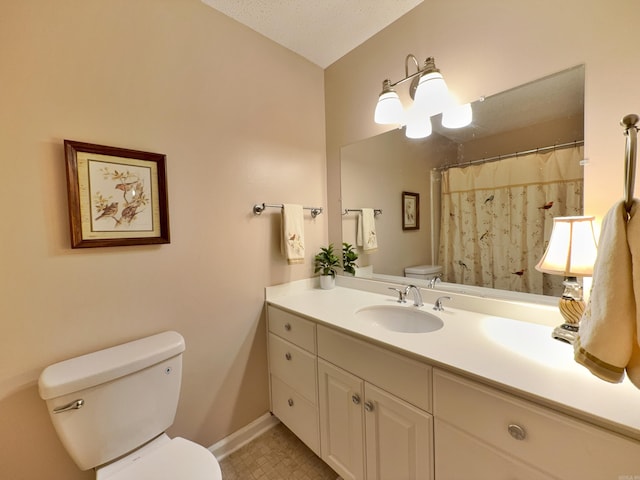 bathroom with toilet, vanity, and baseboards