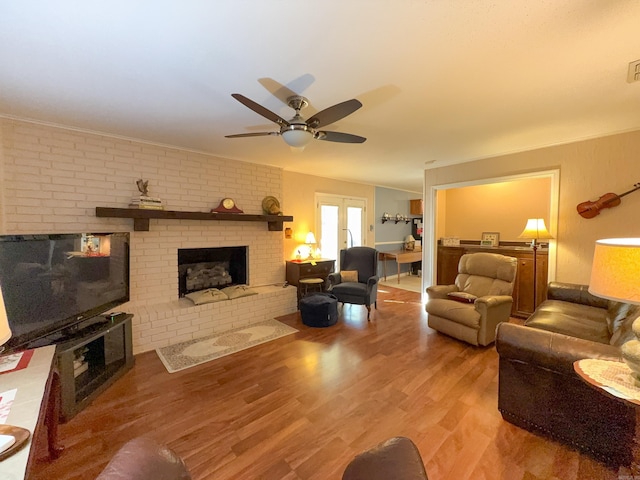 living room with a fireplace, wood finished floors, and a ceiling fan