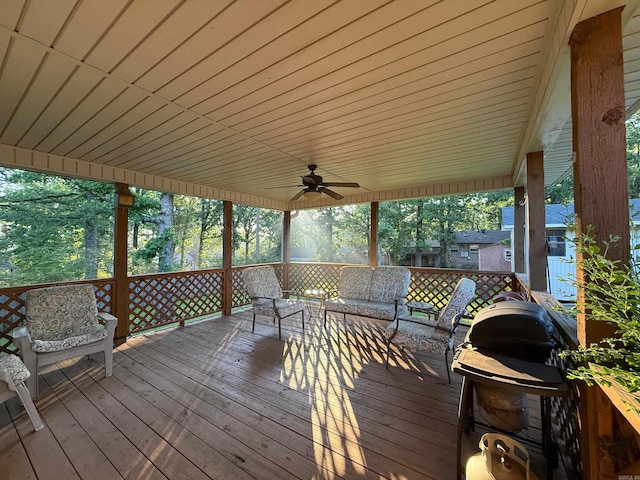 wooden terrace featuring a ceiling fan and an outdoor living space