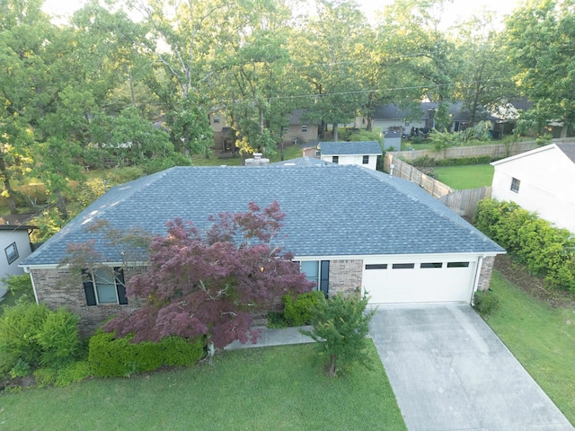 view of front facade with driveway, stone siding, a garage, and roof with shingles