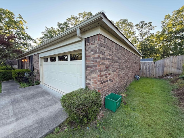 view of side of home featuring concrete driveway, brick siding, and an attached garage