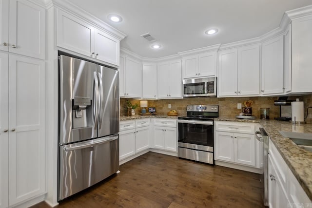 kitchen featuring stainless steel appliances, white cabinetry, backsplash, and recessed lighting