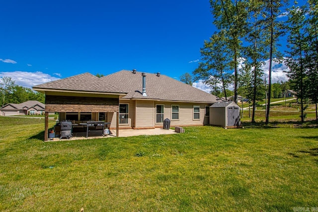 back of property with a patio area, a shed, a yard, an outdoor structure, and a shingled roof