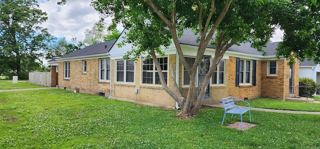 view of home's exterior featuring brick siding, a yard, and roof with shingles