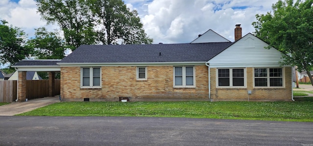 view of side of property featuring brick siding, a carport, and a chimney