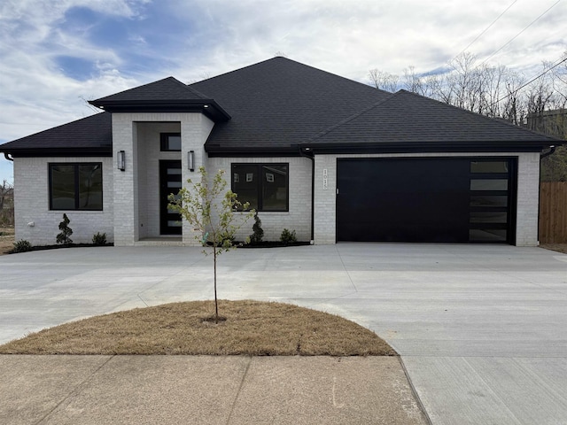 1015 N Shackleford Rd, Little Rock, AR 72211 - contemporary house featuring driveway, brick siding, a garage, and a shingled roof