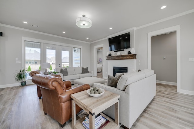 living area featuring ornamental molding, baseboards, light wood-type flooring, a brick fireplace, and recessed lighting