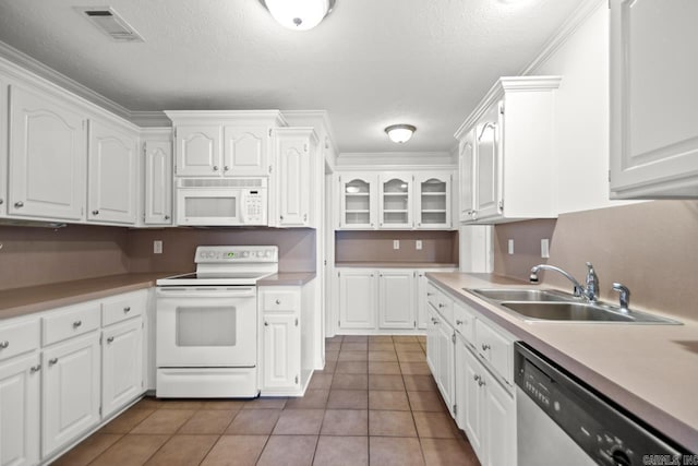 kitchen featuring white appliances, a sink, white cabinetry, and a textured ceiling