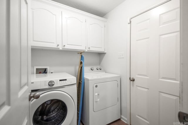 laundry area featuring washing machine and clothes dryer and cabinet space