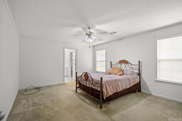 bedroom featuring light colored carpet, crown molding, baseboards, ceiling fan, and ensuite bathroom